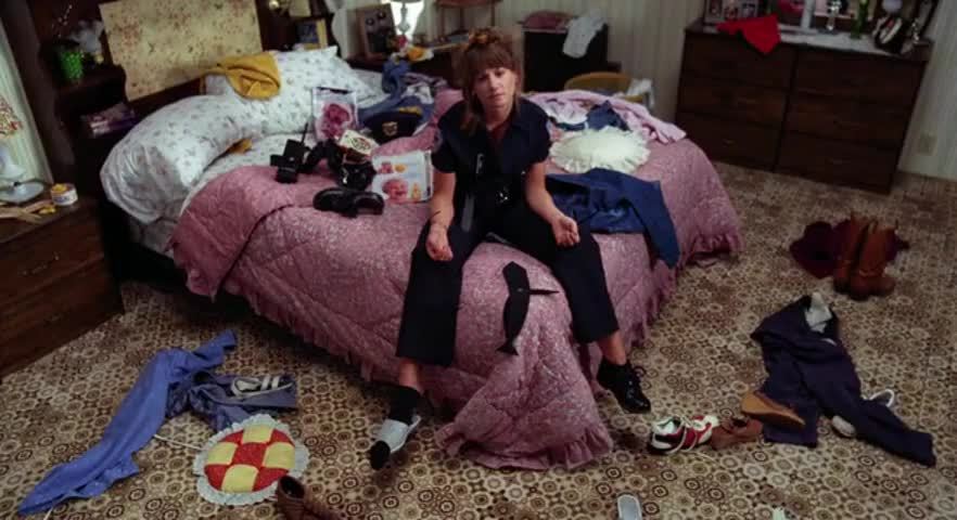 woman in police uniform sits listlessly on a bed; Holly Hunter in Raising Arizona