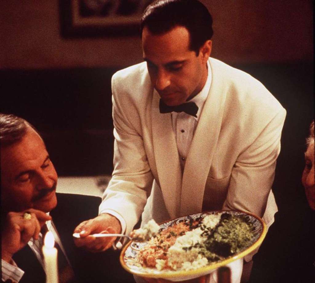 two men smiling at colorful risotto; Ian Holm and Stanley Tucci in Big Night