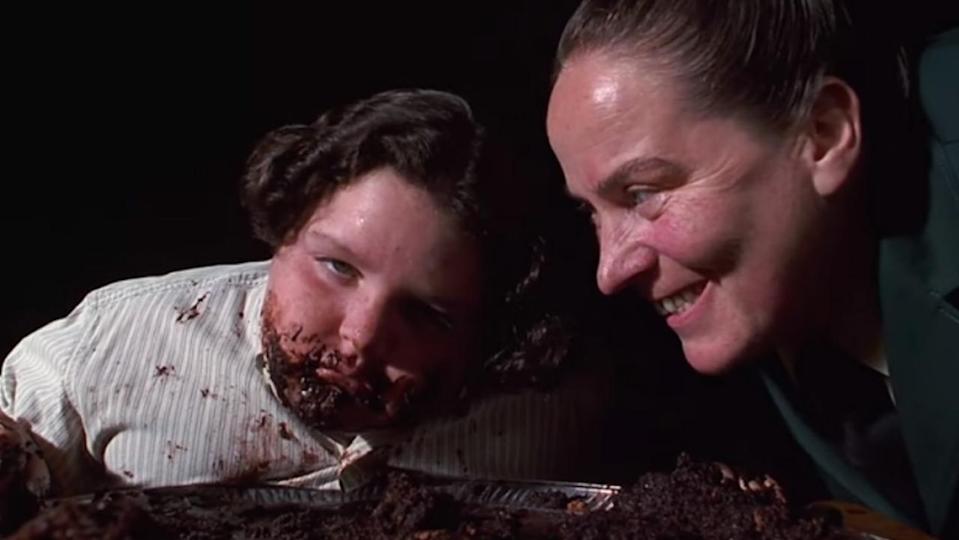 boy with face covered in chocolate cake next to sneering woman; Matilda