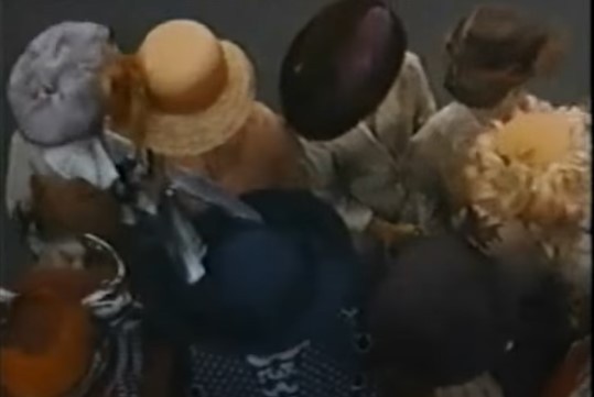 blurred image of tops of women's feathered hats from The Music Man