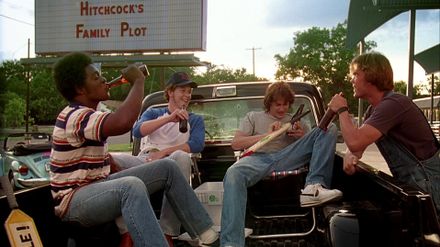 four men sit in the bed of a truck; Dazed and Confused