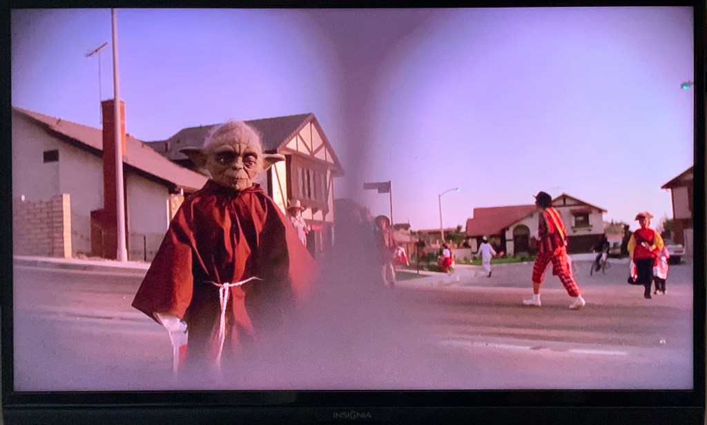 child in yoda mask seen through eye-holes; E.T.