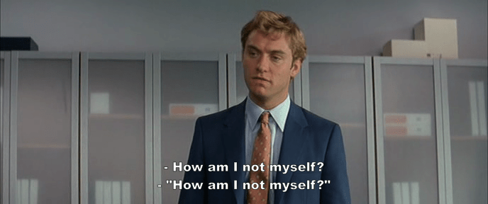 white man with blond hair and suit asks How am I not myself?; Jude Law in I Heart Huckabees