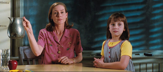 woman holds a pitcher in the air next to a little girl with brown hair; Mara Wilson in Matilda