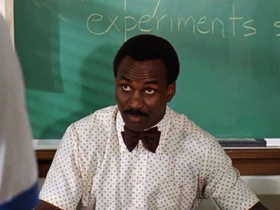 black man sits in front of chalkboard; Dazed and Confused