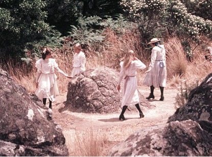 four girls in white dresses in a circle around a boulder; Peter Weir's Picnic at Hanging Rock